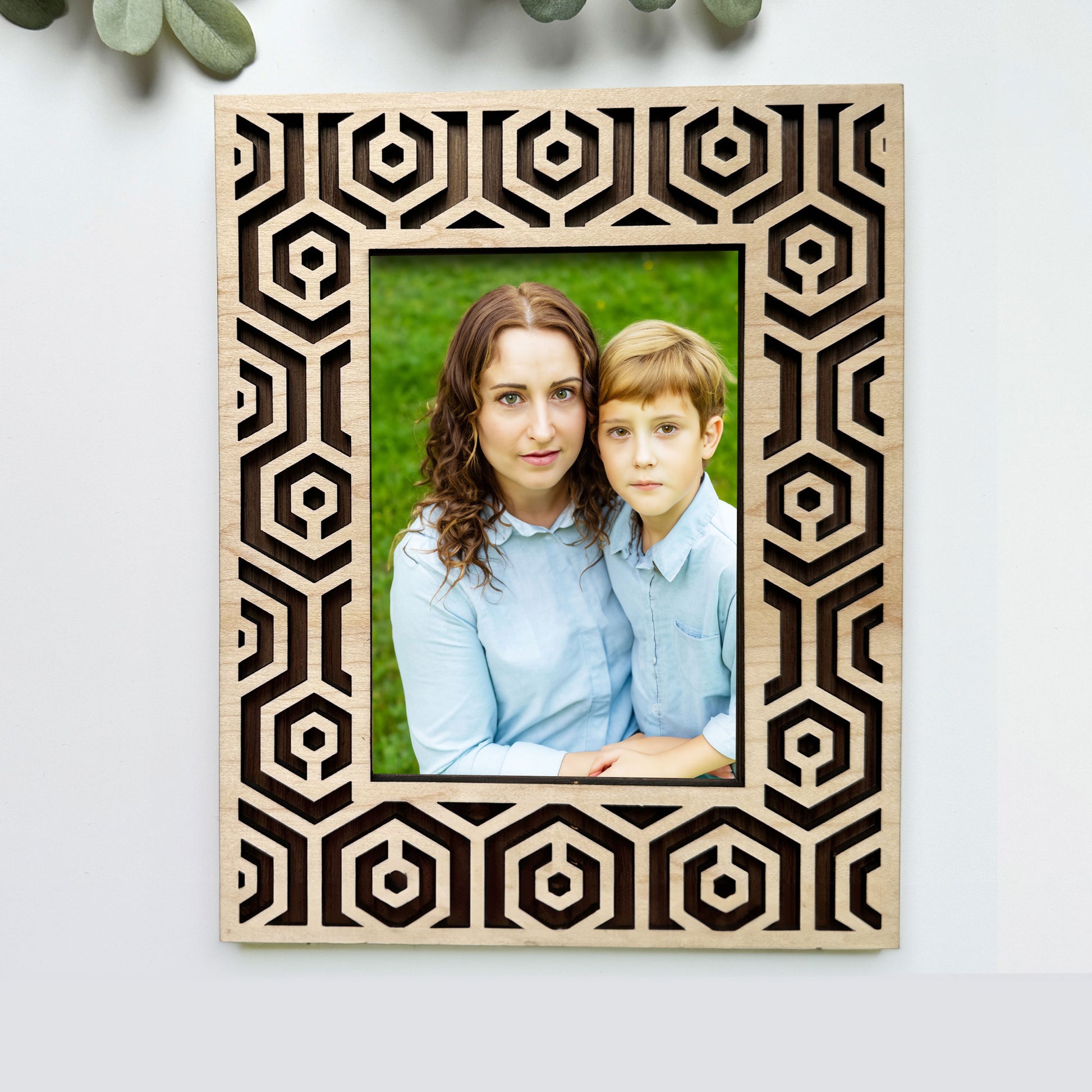 Decorative photo frame with a geometric pattern containing a photo of a woman and a boy.