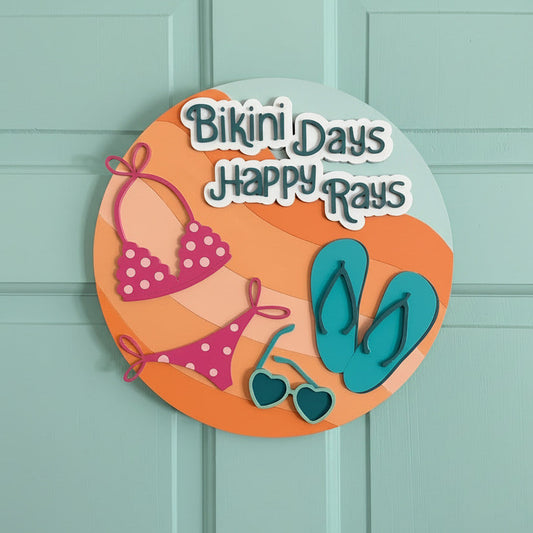 Decorative sign with 'Bikini Days Happy Days' text and beach-themed graphics on a white door.