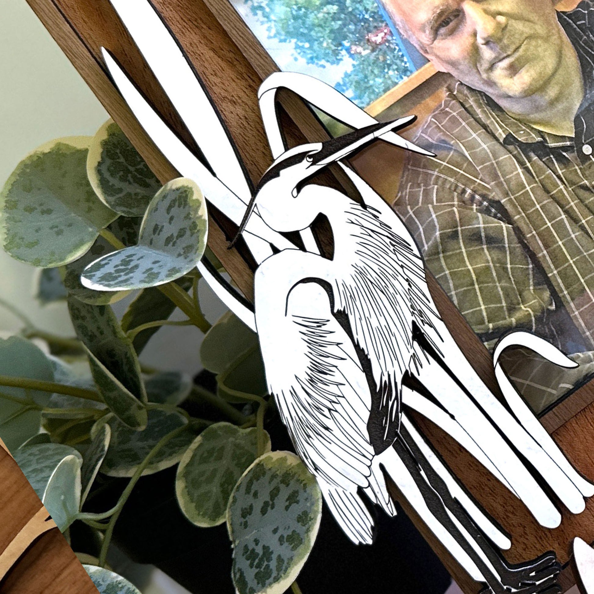 White heron cutout on a wooden stand with a blurred background