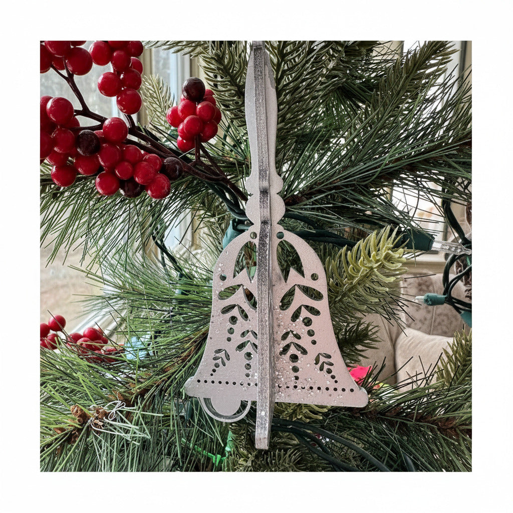 Decorative bell ornament on a Christmas tree with red berries