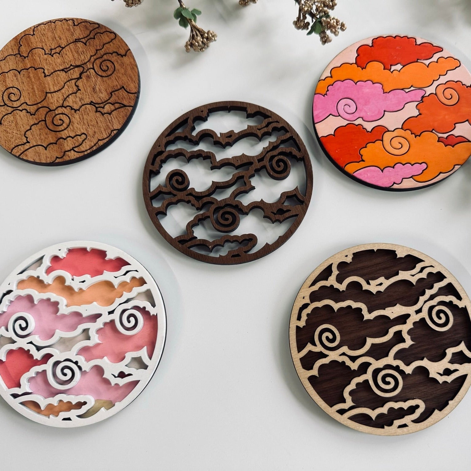 Five decorative coasters with unique patterns on a light background