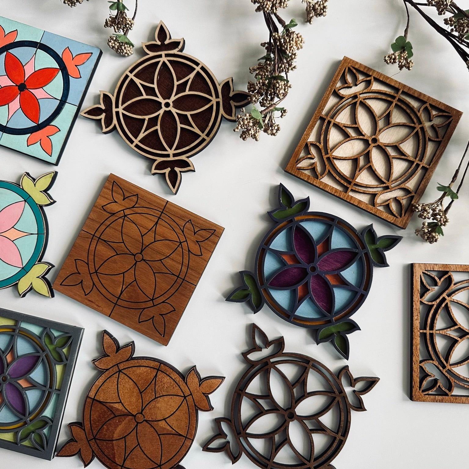 Collection of wooden decorative coasters with floral and geometric patterns on a white background.