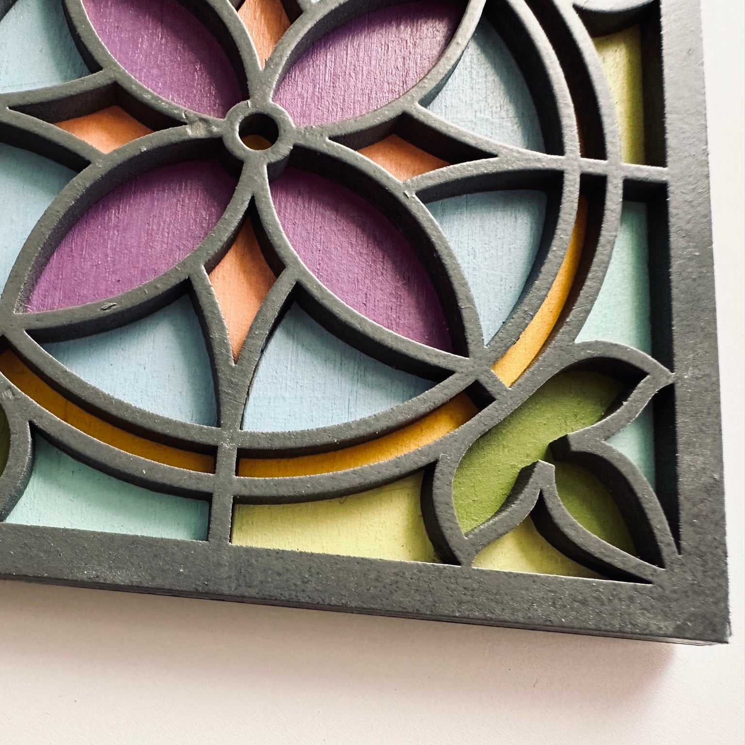 Decorative coasterwith geometric pattern in pastel colors on a light background