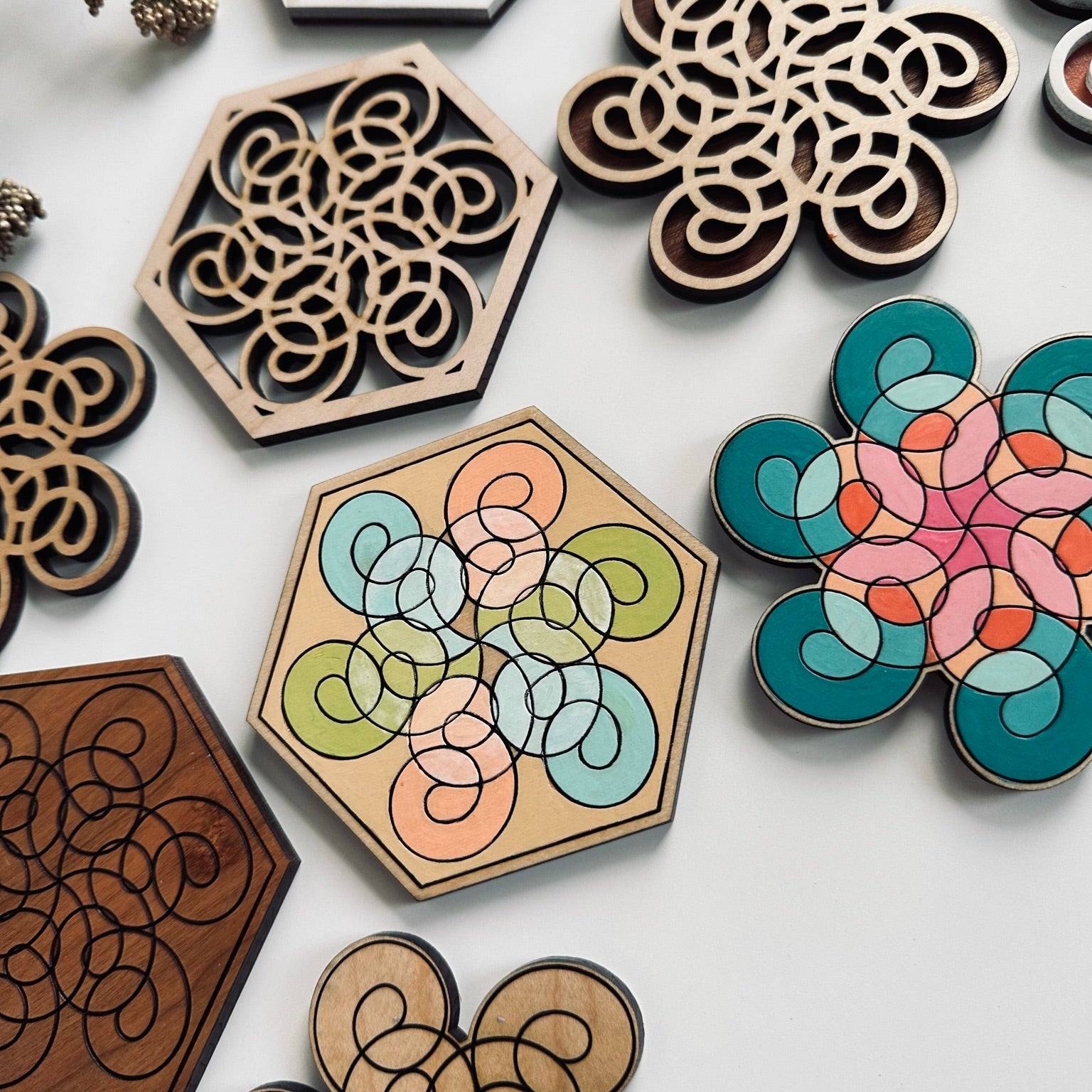 Decorative wooden coasters with intricate patterns on a white surface.