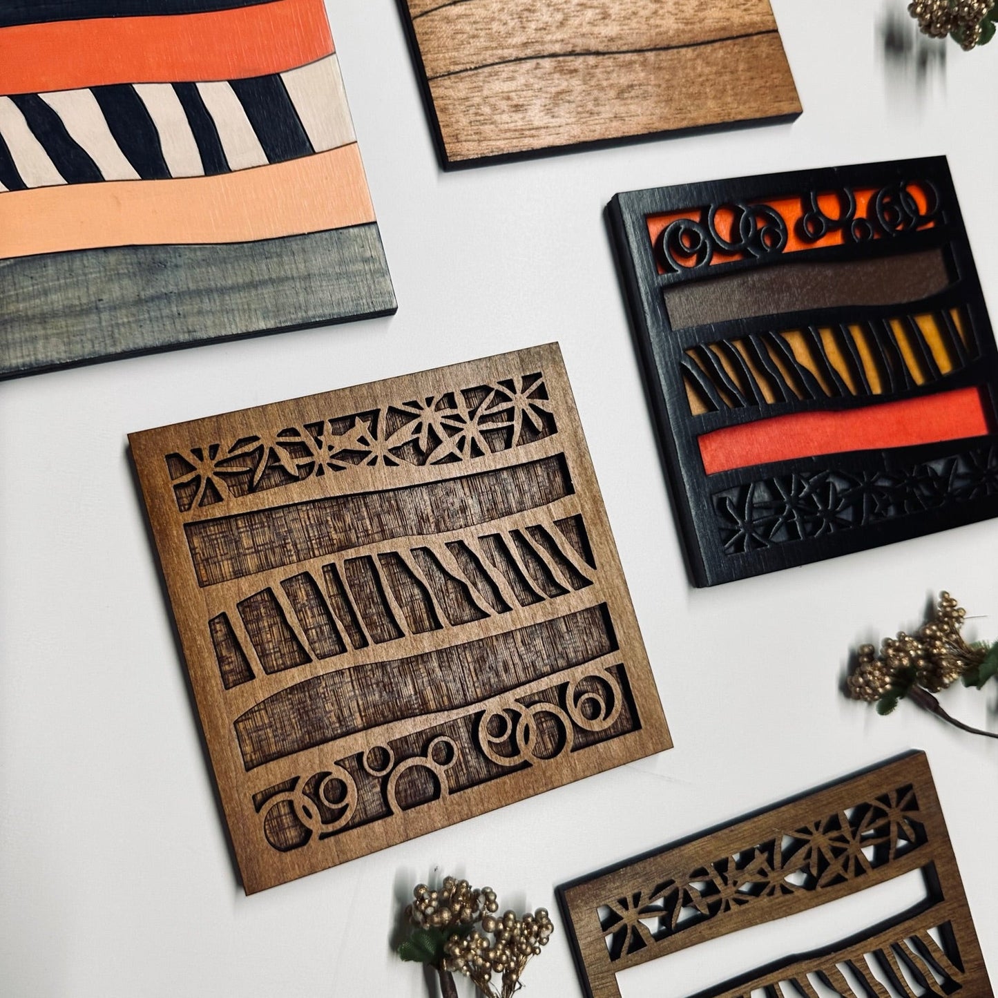 Collection of wooden decorative coasters with geometric patterns on a white surface.