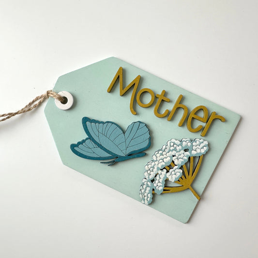 Decorative tag with butterfly and floral design on a light blue background