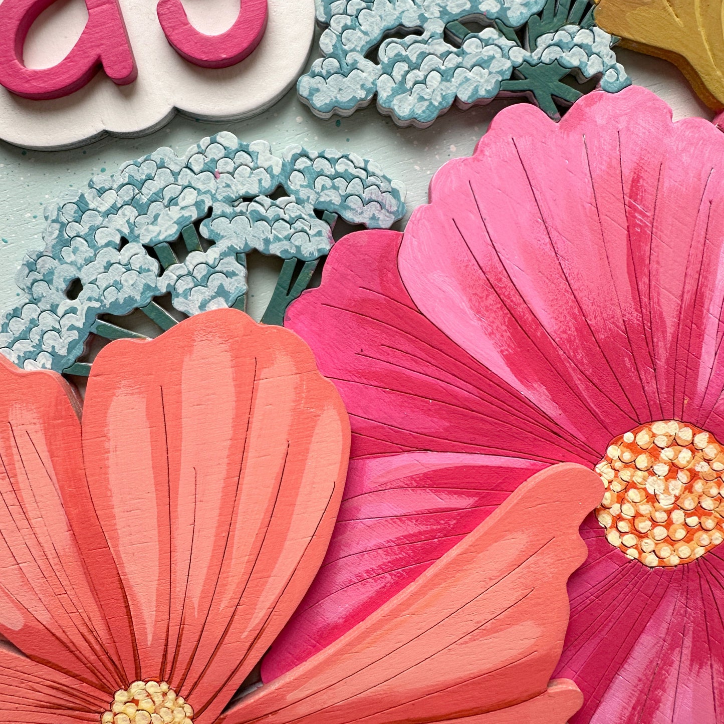 Colorful paper flowers and letters on a textured background