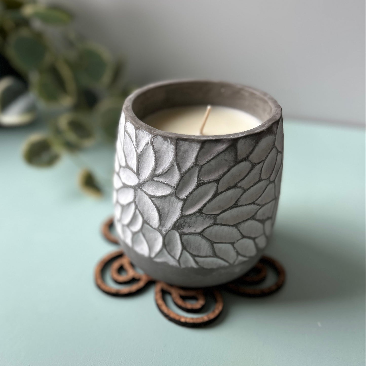 Silver candle holder with intricate design on a light surface