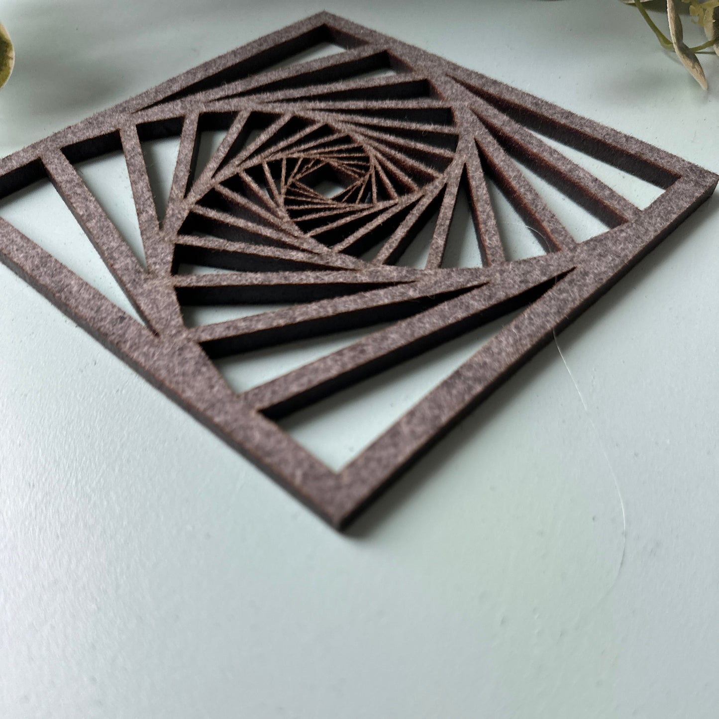 A laser-cut trivet with a decorative design on a light background