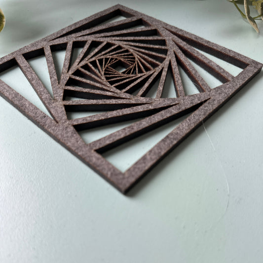 A laser-cut trivet with a decorative design on a light background