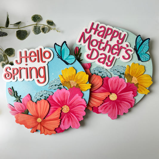 Decorative sign with flowers and text 'Happy Mother's Day' and 'Hello Spring' on a light background.