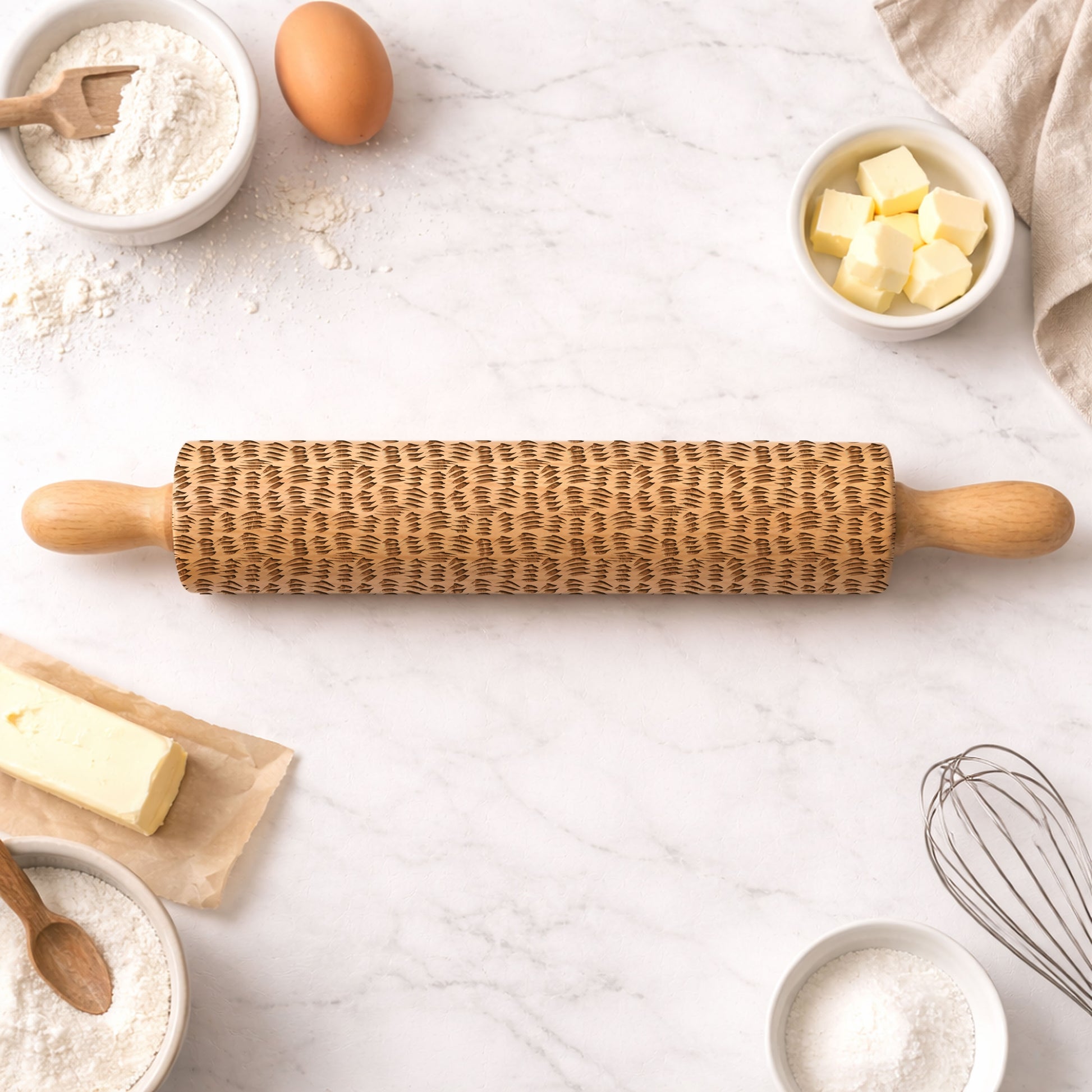 Wooden rolling pin with plant pattern on a kitchen counter with baking ingredients.