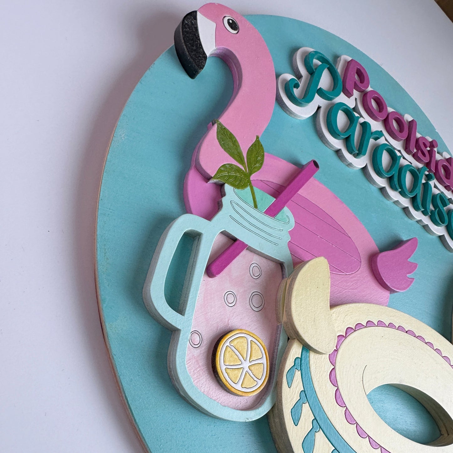 Decorative wall piece with flamingo, drink, and moon design on a light blue background