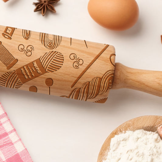 Wooden rolling pin with engraved patterns on a kitchen counter with flour and eggs.
