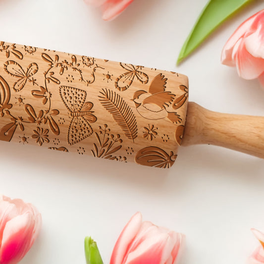 Wooden embossing rolling pin with floral patterns on a light background with tulips.