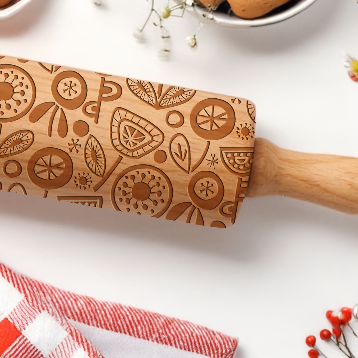 Wooden rolling pin with engraved patterns on a white surface