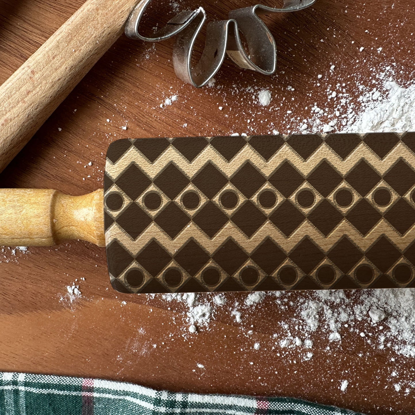 Wooden rolling pin with a pattern on a wooden surface with flour.