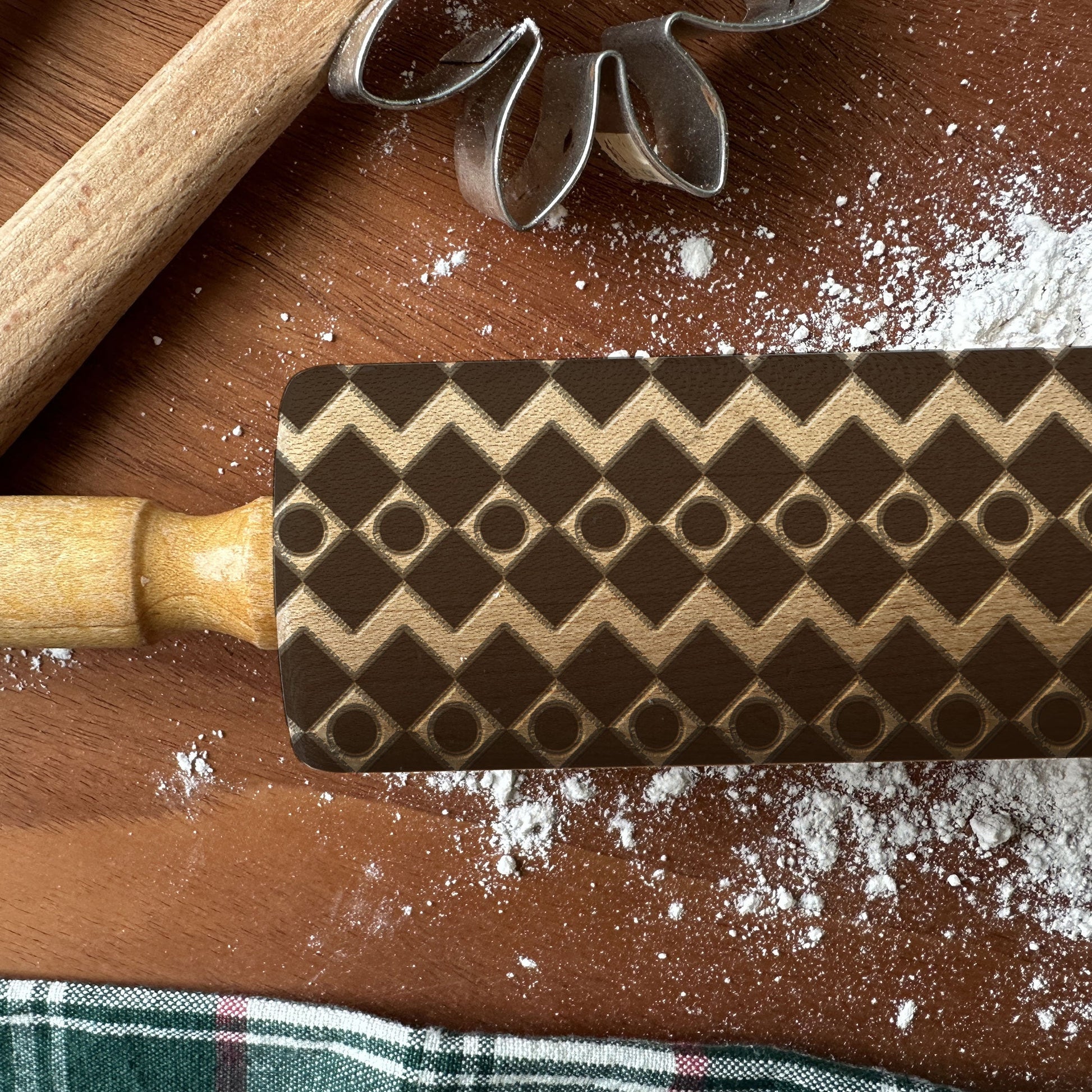 Wooden rolling pin with a pattern on a wooden surface with flour.