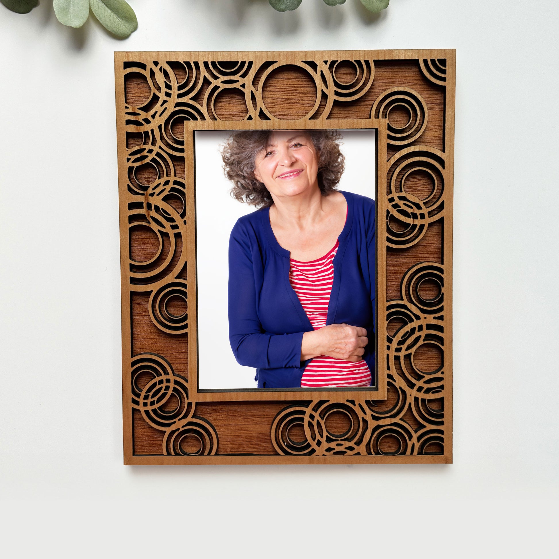 Wooden photo frame with intricate cut-out design, containing a portrait of a woman.