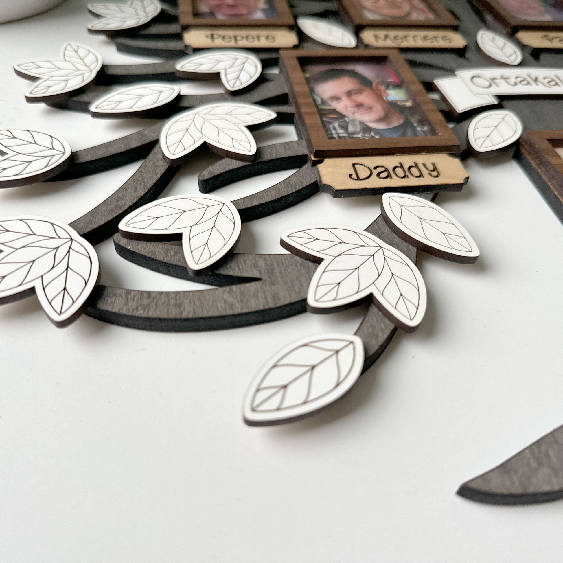 Family tree with wooden leaves and family photos on a white background