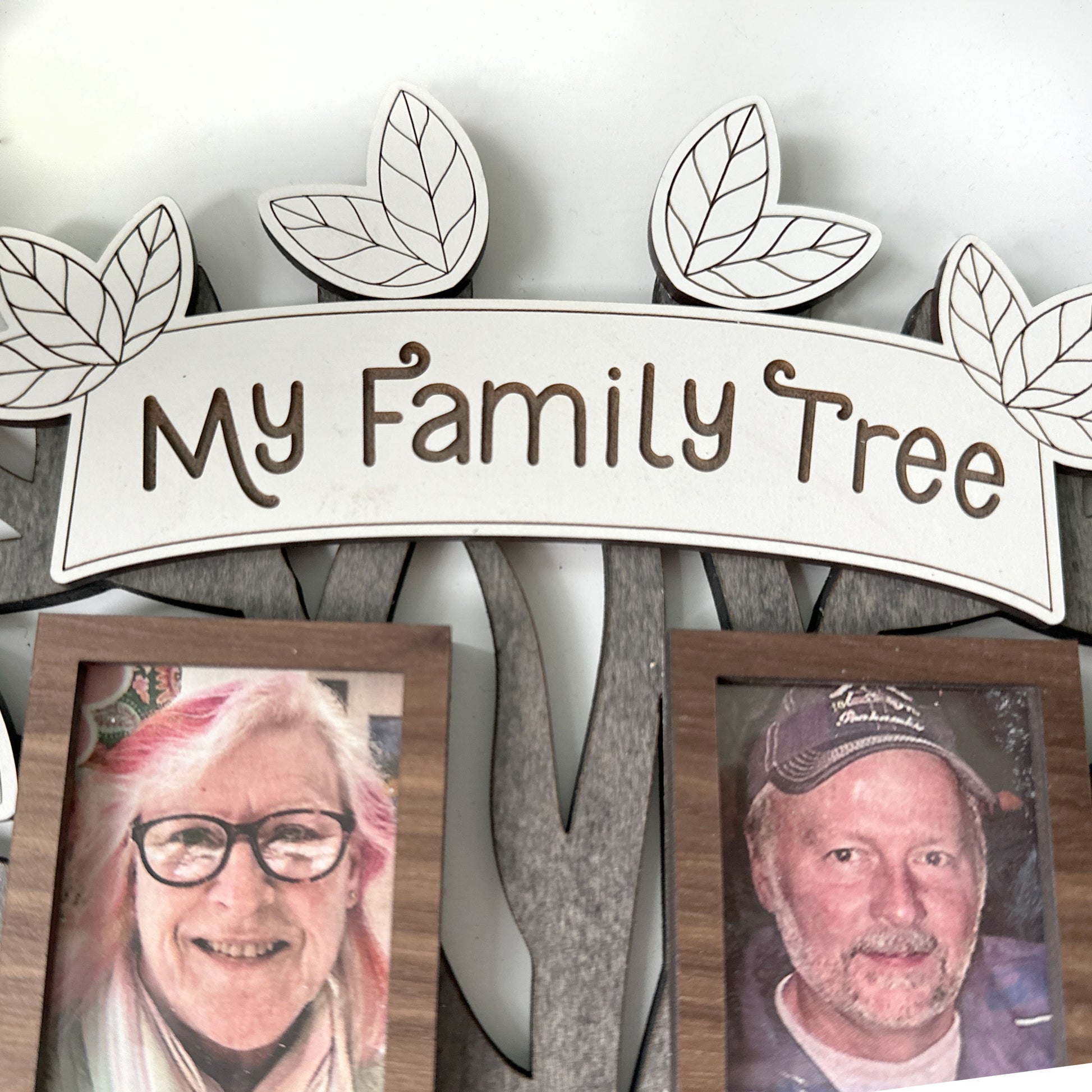 Decorative wall piece with 'My Family Tree' sign and two framed photos of an elderly couple.
