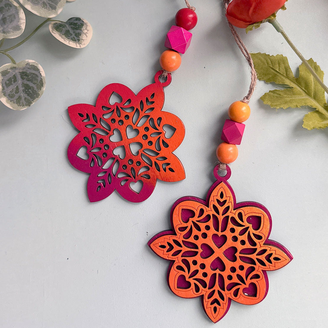 Decorative floral ornaments with colorful beads on a light background