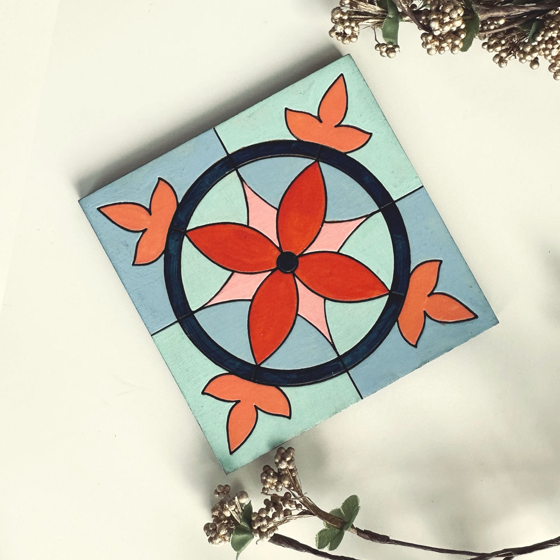 Decorative coaster with a floral design on a light blue background
