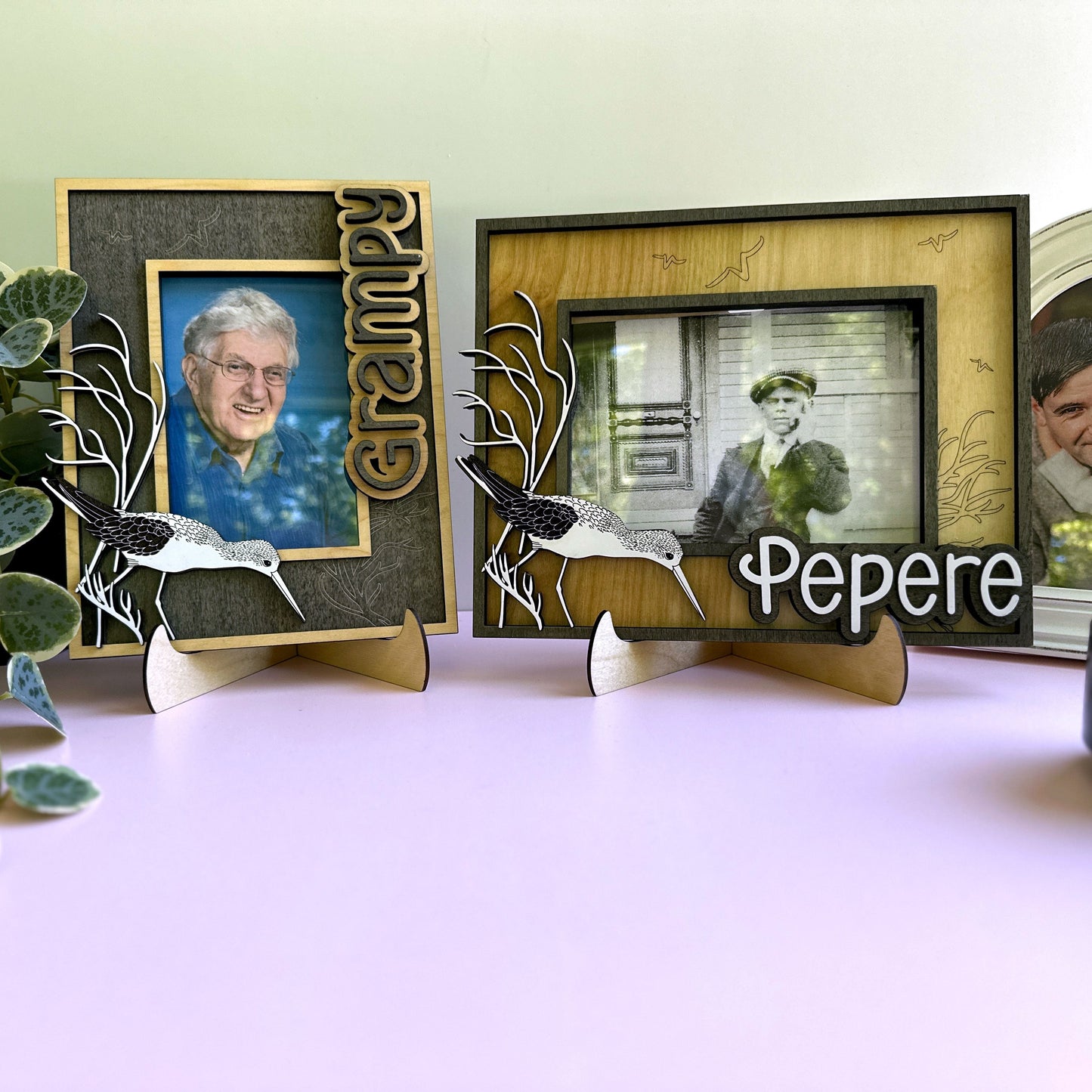 Three decorative photo frames with engraved names and family photos on a light surface.