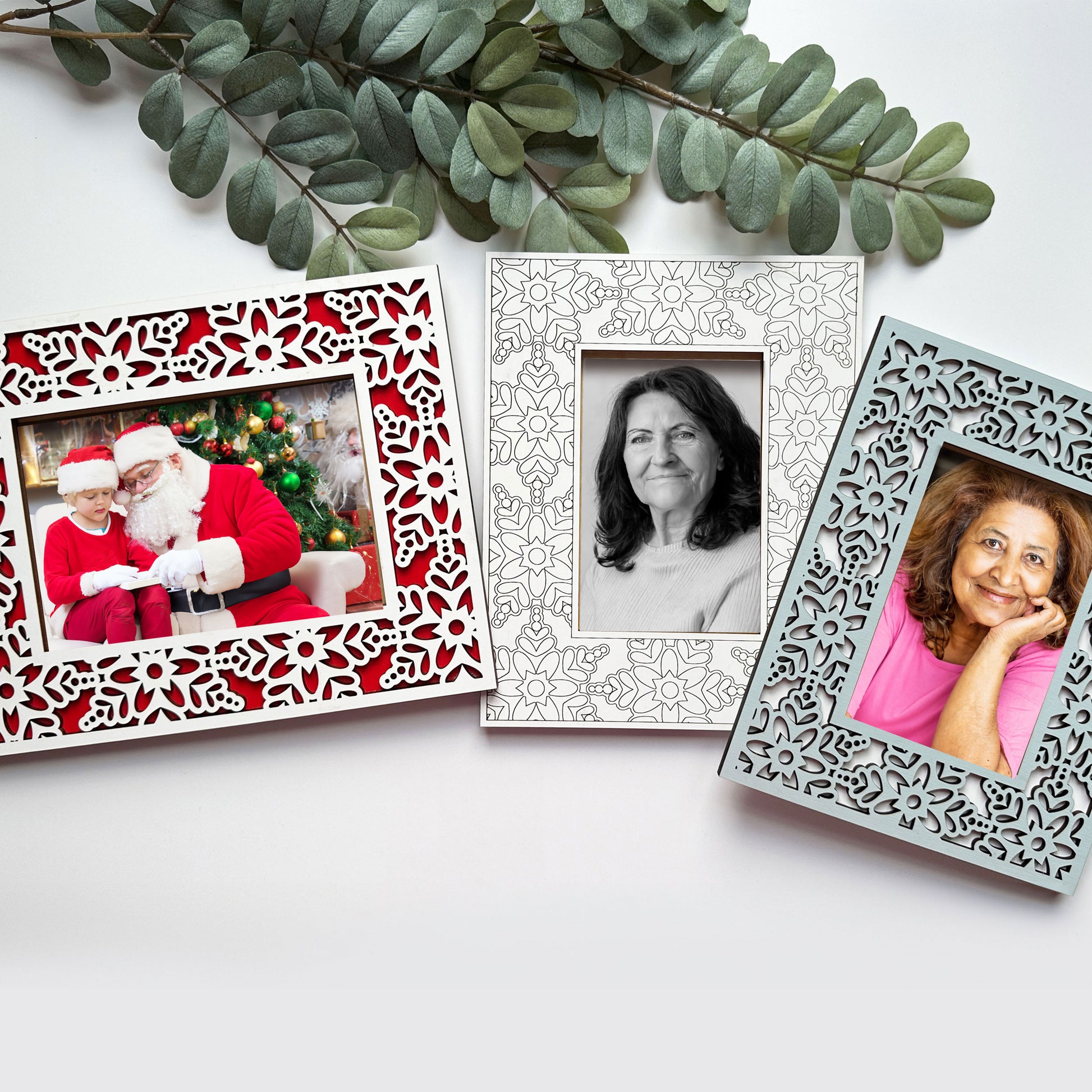 Three decorative photo frames with different images on a white surface.