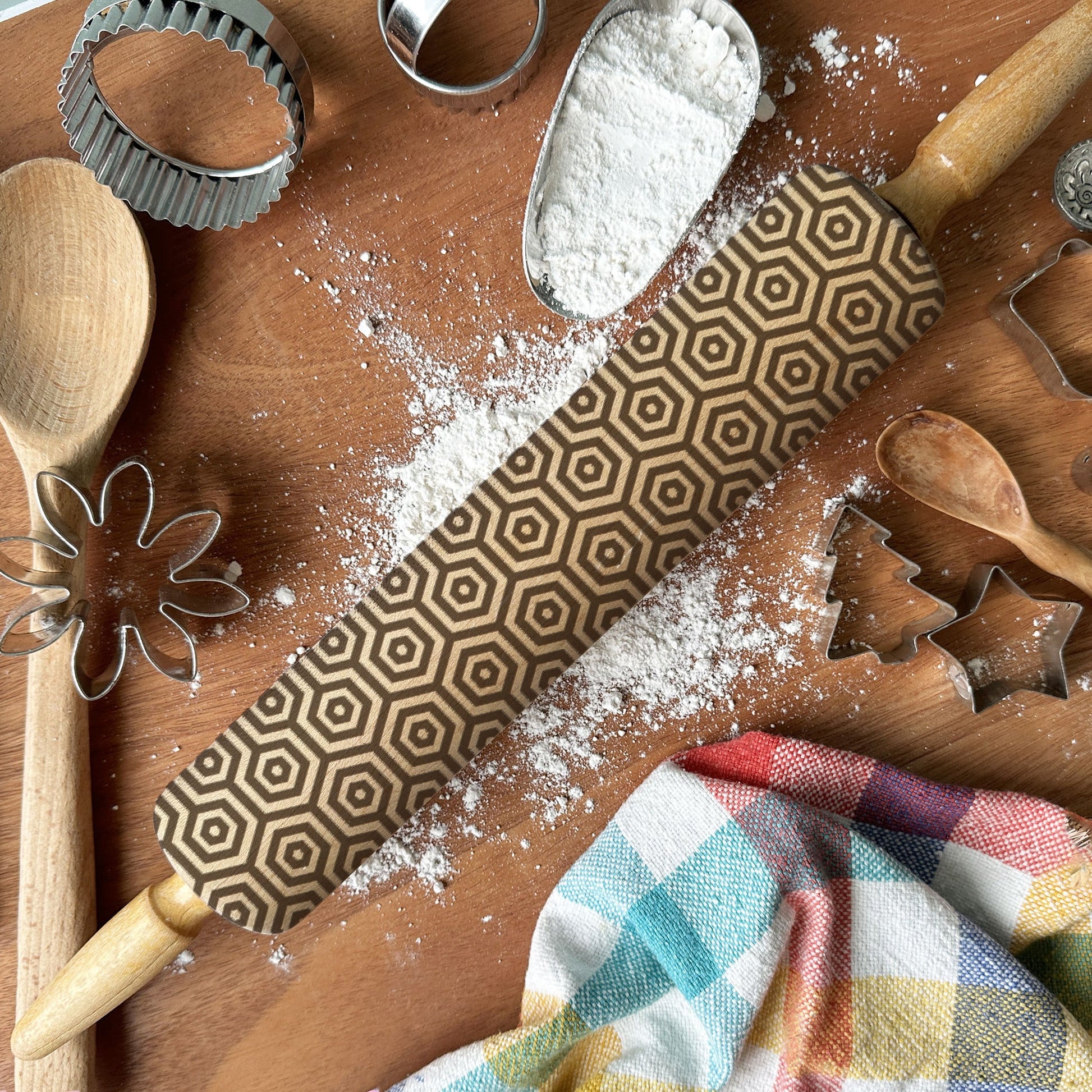 Wooden kitchen utensils and rolling pin on a wooden surface with flour.