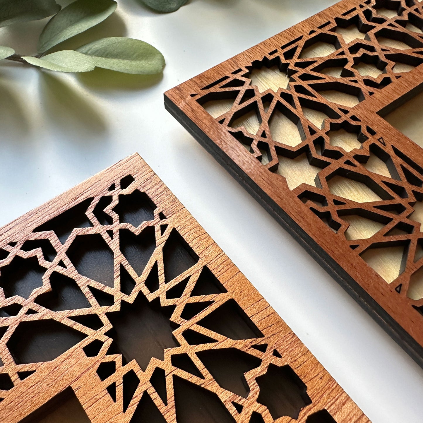 Two wooden decorative panels with intricate geometric patterns on a light background.