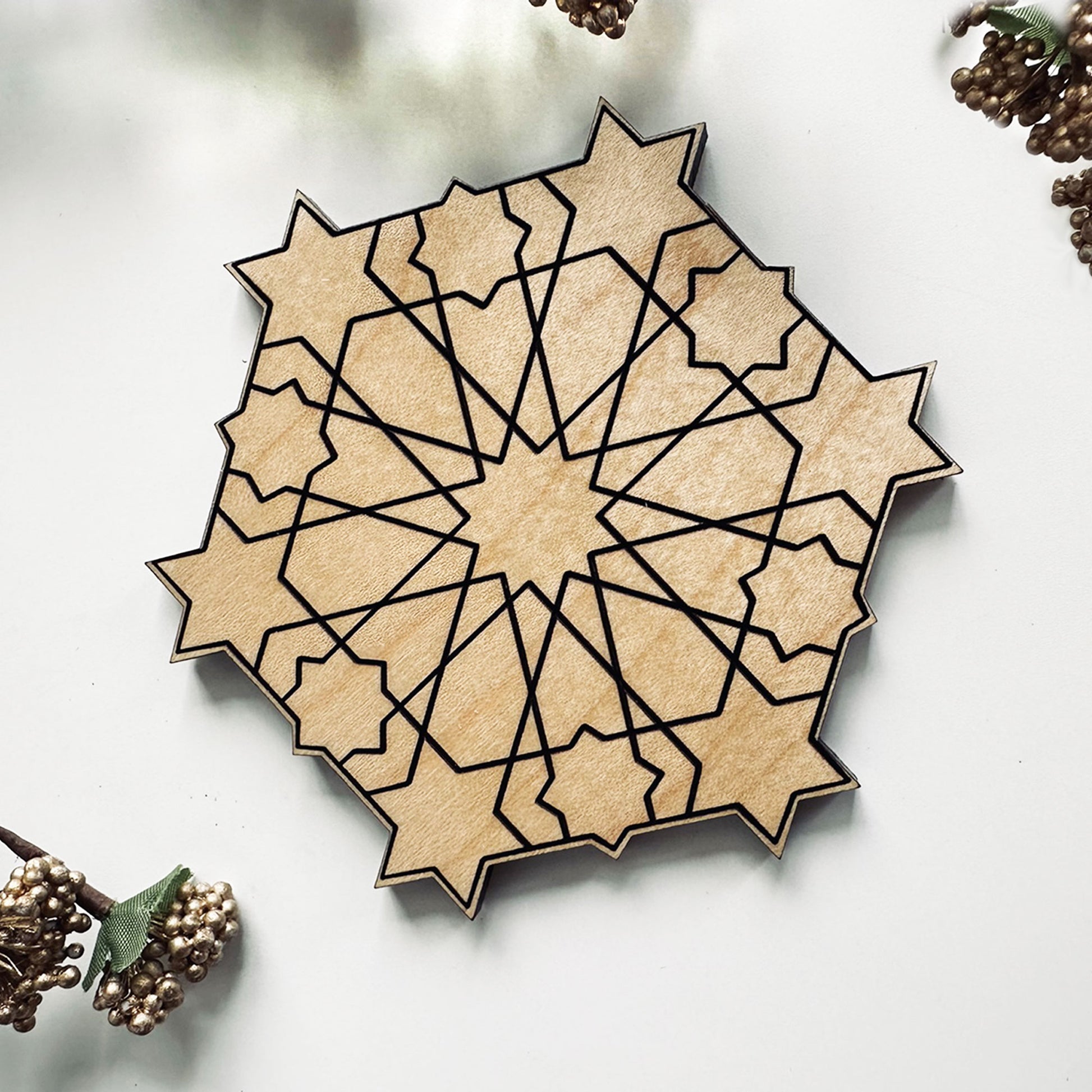 Geometric wooden coaster with star patterns on a light background